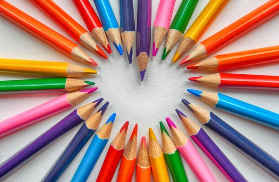 Group of sharp colored pencils arranged so their points together outline the shape of a heart.
