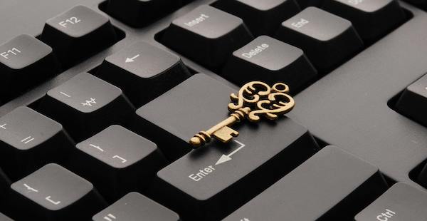 Small, ornate gold key sitting on a computer keyboard